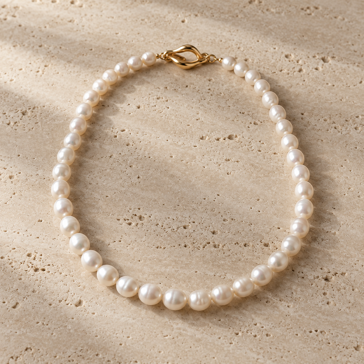 Aurelia Pearl Strand Necklace on warm travertine